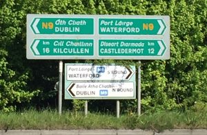 Road signs in Ireland provide directions and a lesson in Irish. 